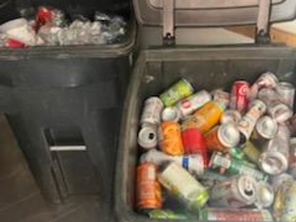 Two bins filled with empty cans and plastic bottles for recycling.