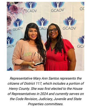 Two women smiling at a GCADV event, one holding an award.