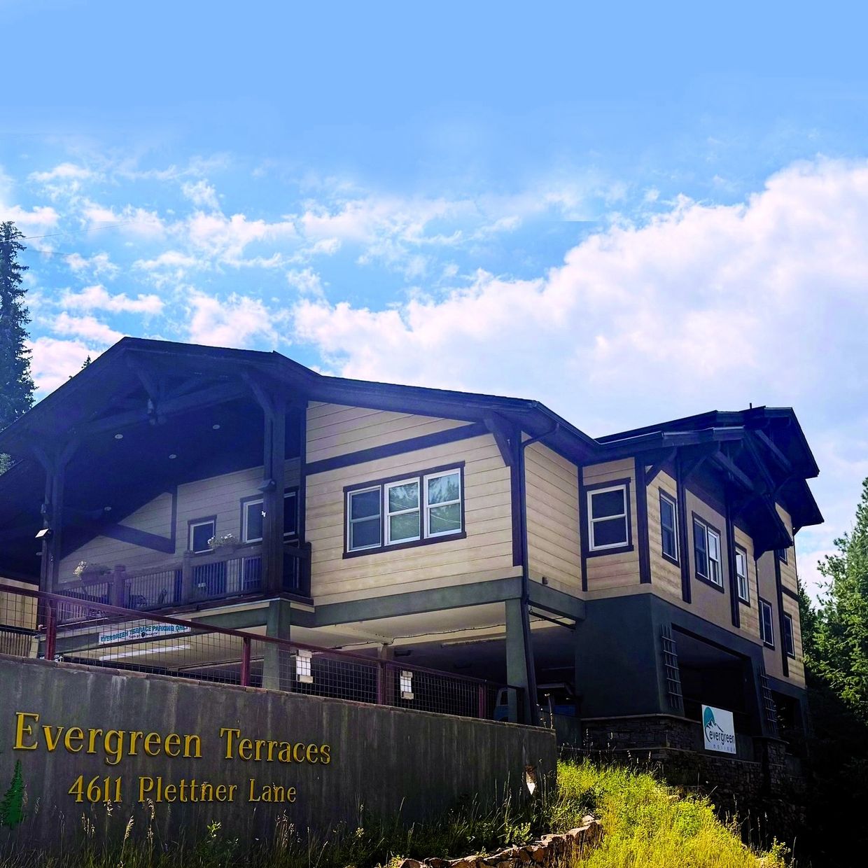 Modern residential building named Evergreen Terraces under a blue sky.