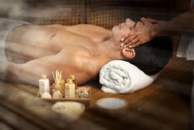 Man receiving a head massage in a spa setting.