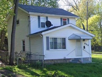 Two-story white house with a small front porch and satellite dish.