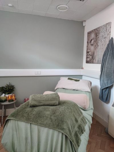 Cozy massage or therapy room with a bed and calming decor.