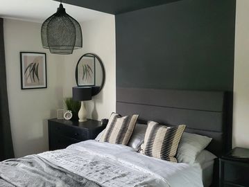 Modern bedroom with gray accents and decorative pillows.