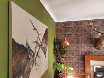 Interior wall with moose painting and mounted deer head.