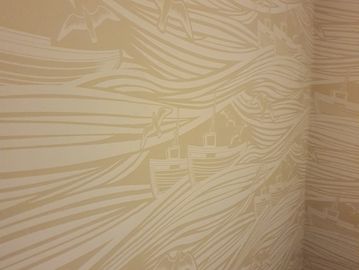 Wall mural with boats and birds in a flowing wave design.
