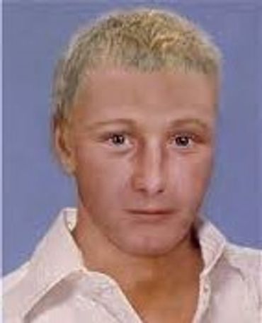 Portrait of a young man with short blond hair and a white shirt.