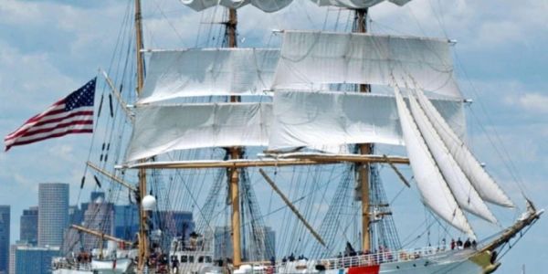 A tall ship with sails and American flag.