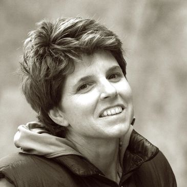 Black and white portrait of a smiling woman with short hair.