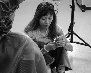 Woman sitting on floor using smartphone.