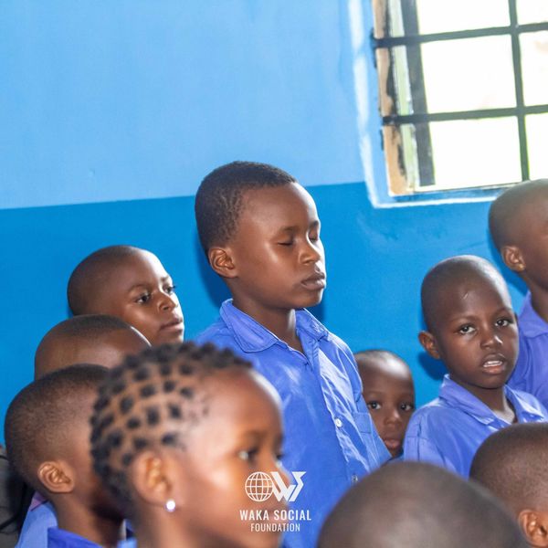 Children in blue uniforms in a classroom setting.