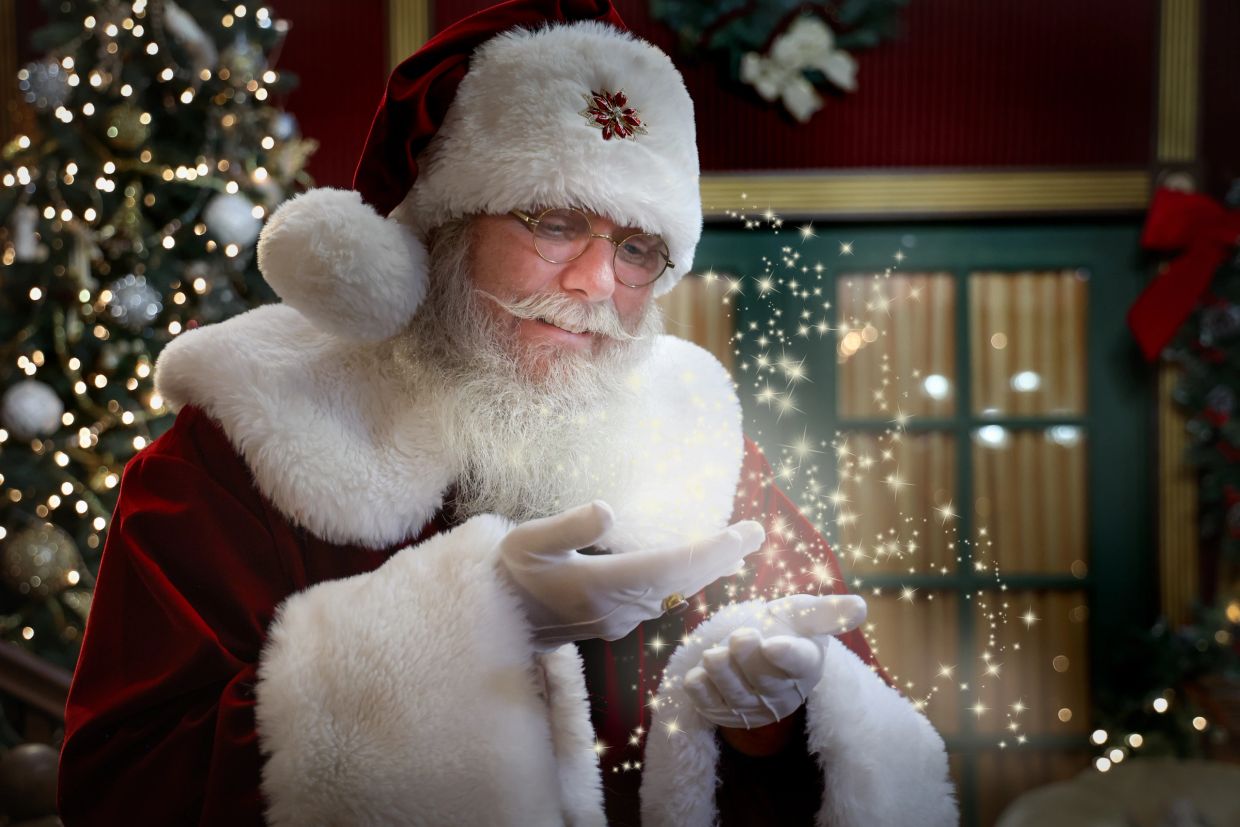 Santa Claus holding sparkling magic dust in his hands.