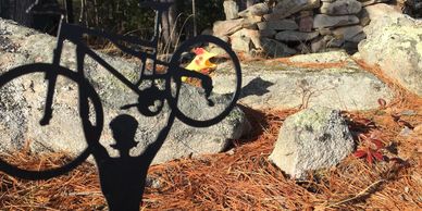 Shadow of a person lifting a bicycle over their head outdoors.