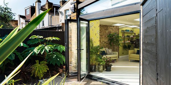 Open garden doors and roof glazing at the completed Newham wraparound extension.