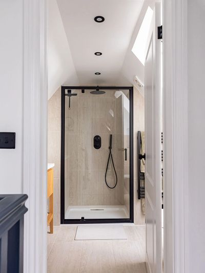 Modern bathroom with a sleek black-framed glass shower enclosure and minimalist fixtures.