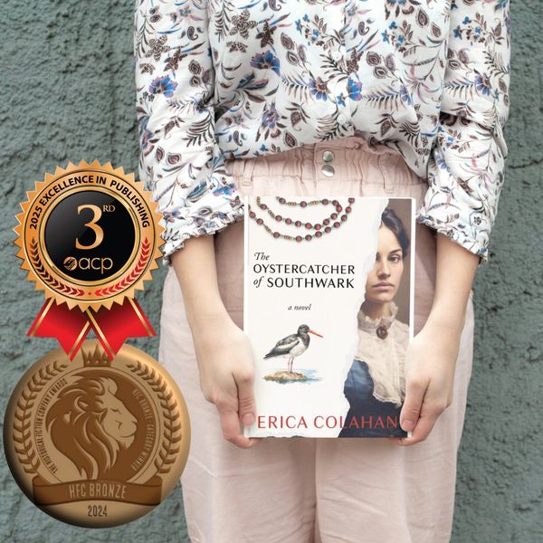 Woman holding a copy of The Oystercatcher of Southwark with two bronze medals.