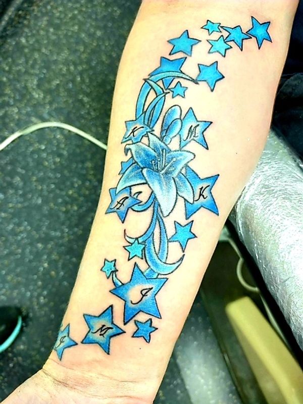 stars with significant letters/initials inside them on a forearm tattoo