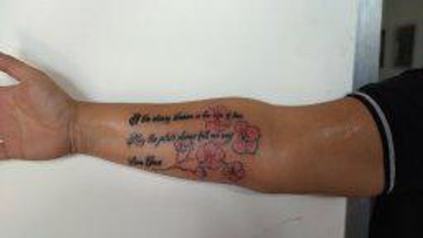 flowers with script forearm tattoo