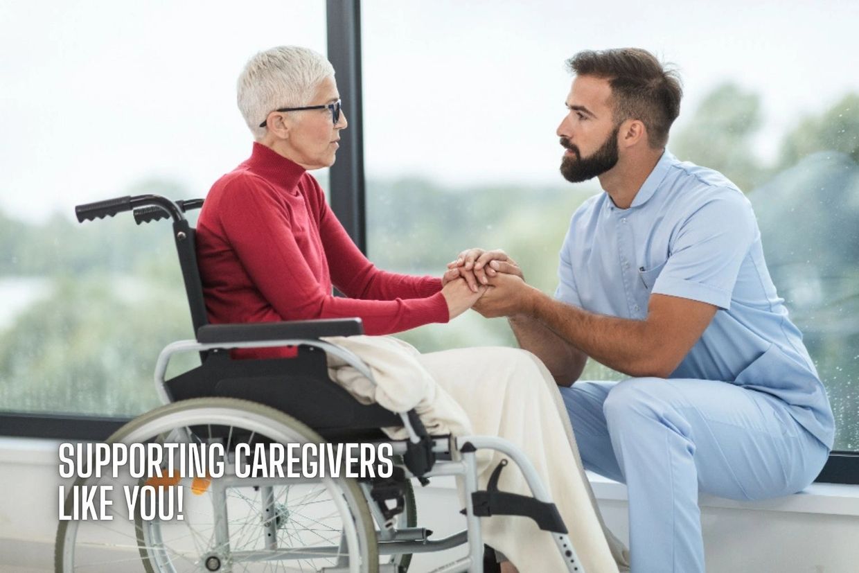 Caregiver kneeling and holding hands with elderly woman in wheelchair, showing support.