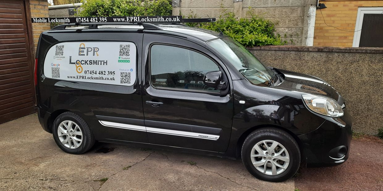 A local Locksmith, black emergency locksmith services van with company branding and contact details.