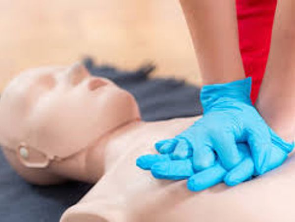 Person performing CPR on a mannequin.