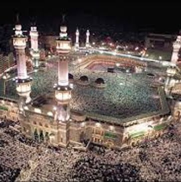 A night view of the Grand Mosque filled with worshippers.