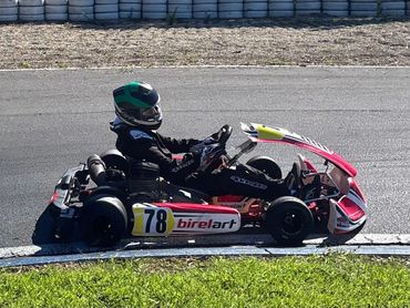 Child racing in a go-kart on a track.