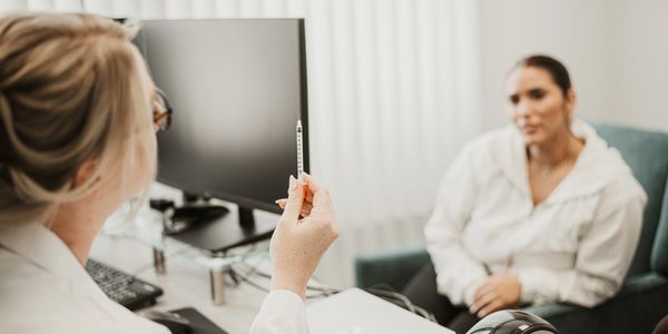 Doctor showing a syringe to a patient in a consultation room.