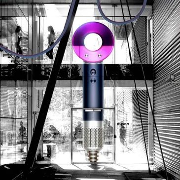 Modern Dyson vacuum display with purple circular top in a glass entrance.