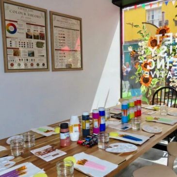 Art supplies arranged on table in a sunlit room.