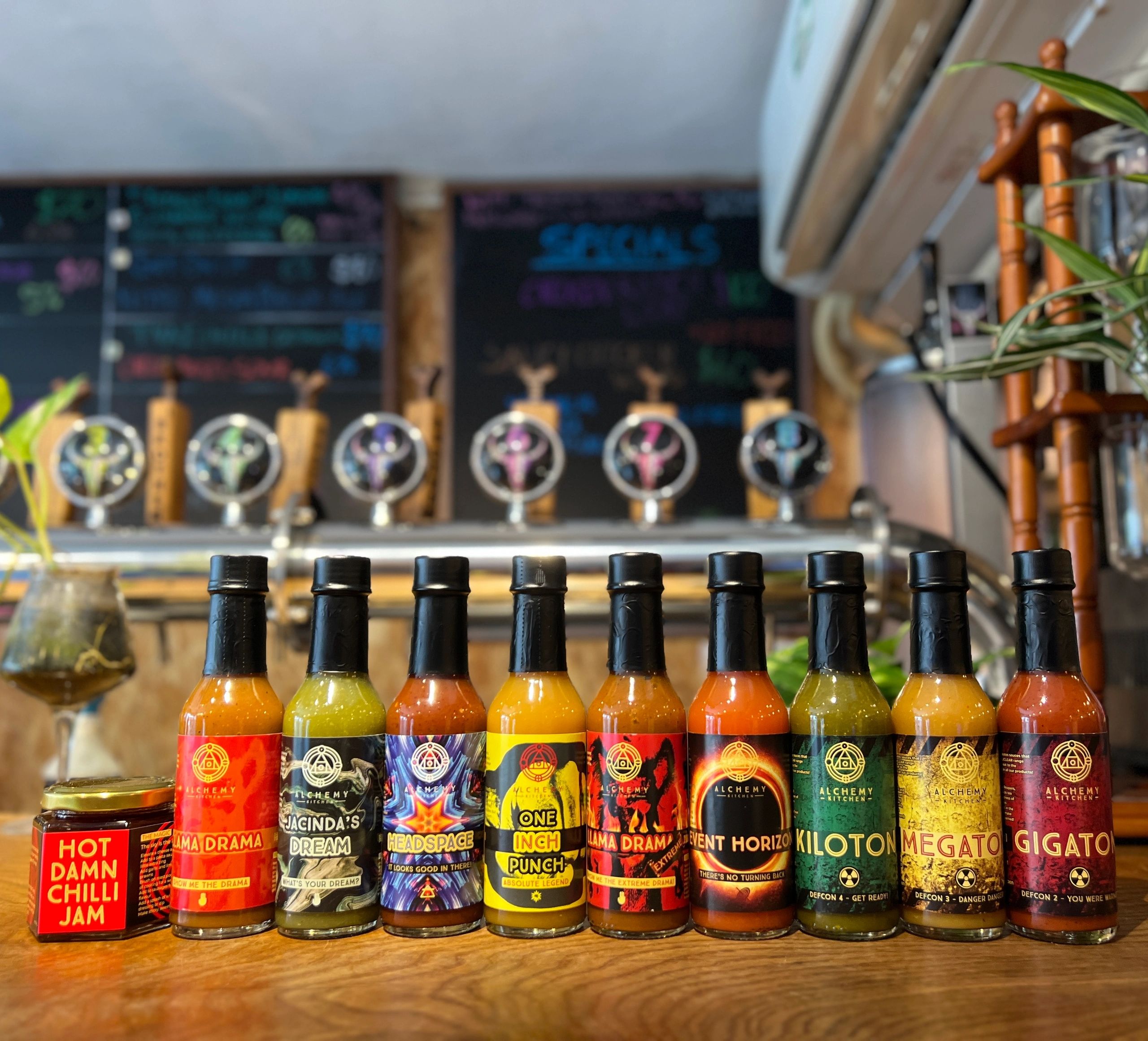 Selection of hots sauce bottles and jam on bar