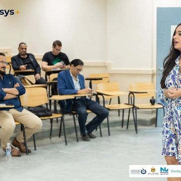 Woman speaking in front of an audience in a classroom.