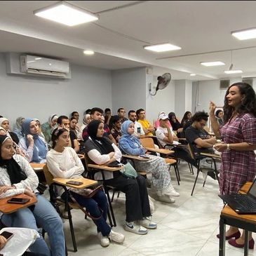 A woman teaching a classroom of attentive students.