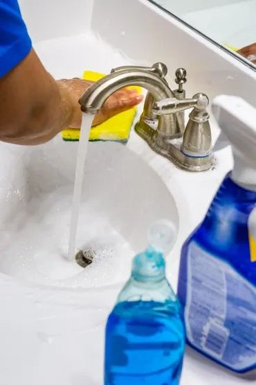 A person cleaning a sink