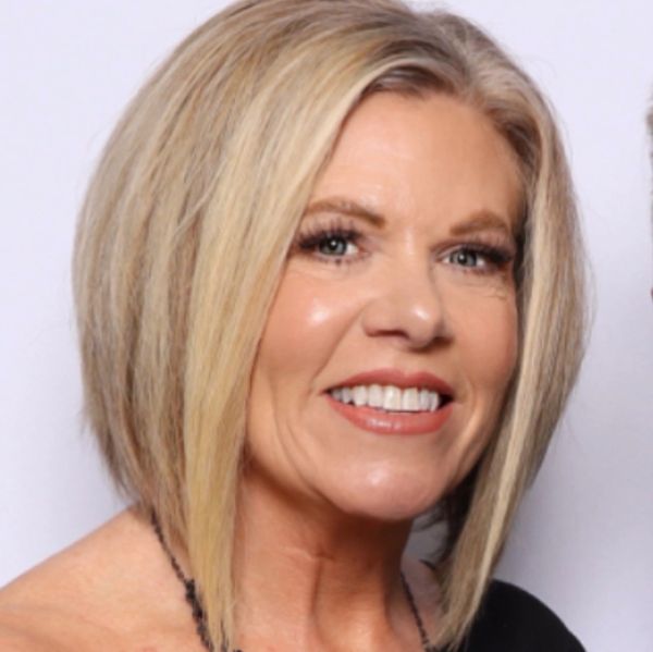 Smiling woman with blonde bob haircut and flawless makeup.