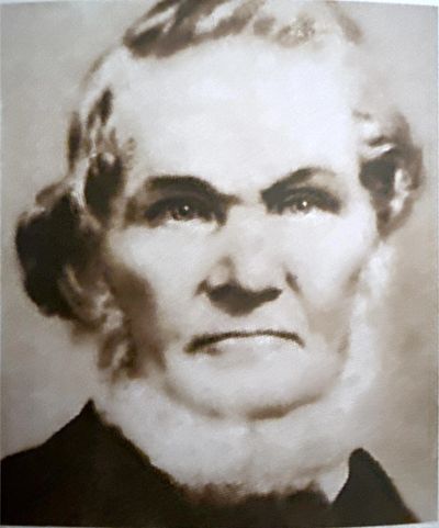 Black and white portrait of an elderly woman with a serious expression.
