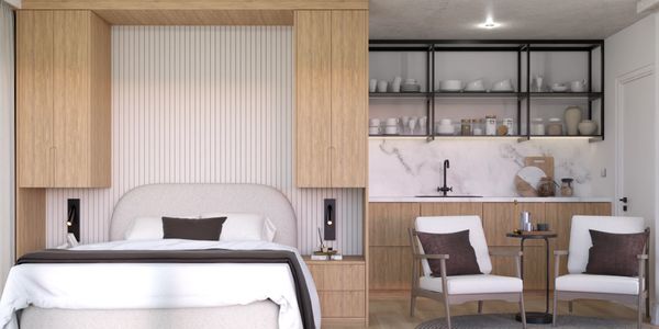 Modern bedroom with wooden accents and a cozy seating area next to a kitchenette.