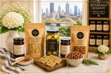 Assorted artisanal food products with Pittsburgh skyline backdrop.