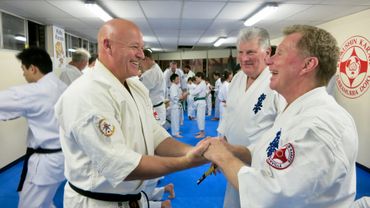 Shihan Rick Cunningham greeting Kancho Turnbull with Hanshi Howard looking on