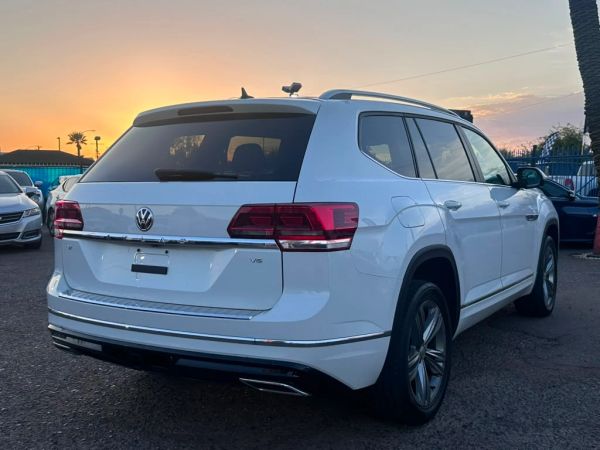 White Volkswagen SUV parked at sunset.