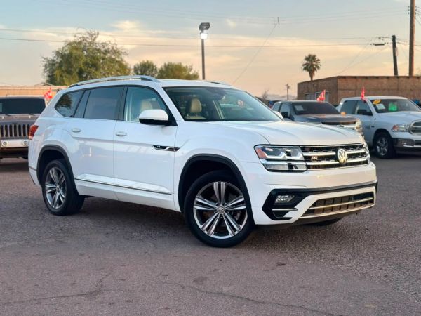 White Volkswagen SUV parked outdoors at sunset.