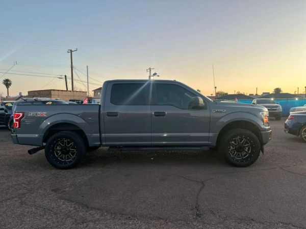 Gray Ford F-150 pickup truck parked at sunset.