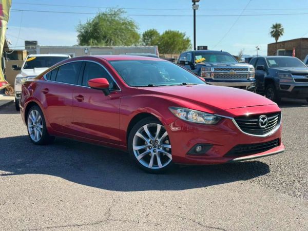 Red Mazda sedan parked in a lot.
