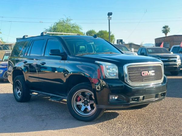 Black GMC SUV parked outside on sunny day.