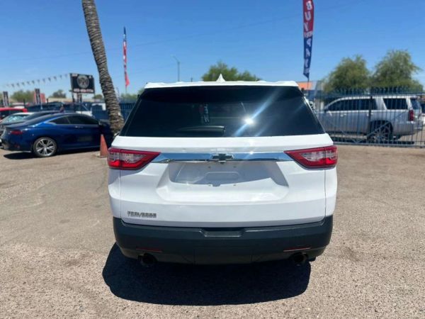Rear view of a white Chevrolet Traverse SUV parked outdoors on a sunny day.