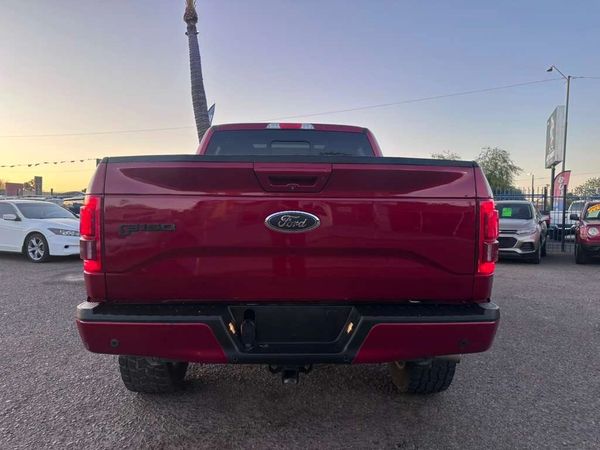 Rear view of a red Ford F-150 pickup truck parked outdoors.