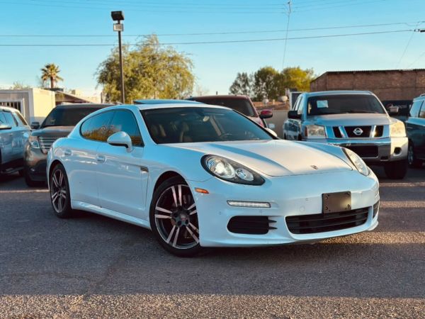 White Porsche parked in an outdoor lot.