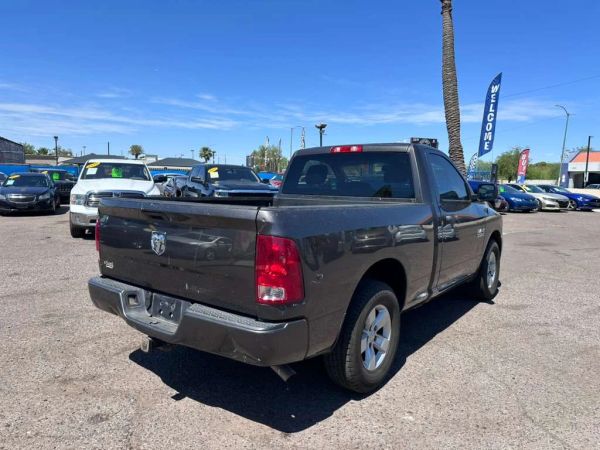 Gray Dodge Ram pickup truck parked at a car lot on a sunny day.