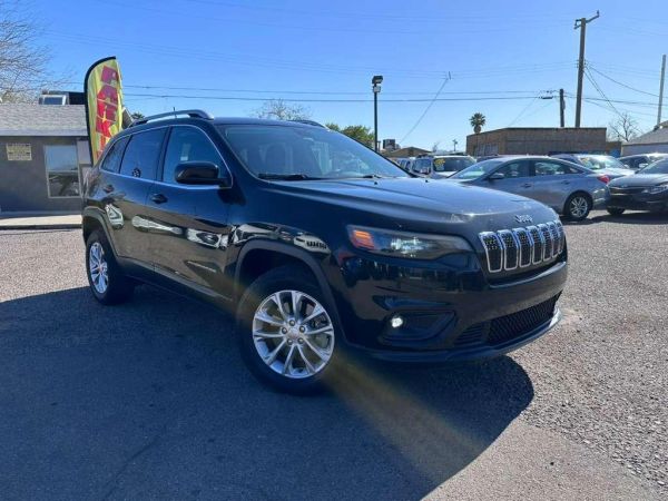 Black Jeep SUV parked outdoors under clear sky.