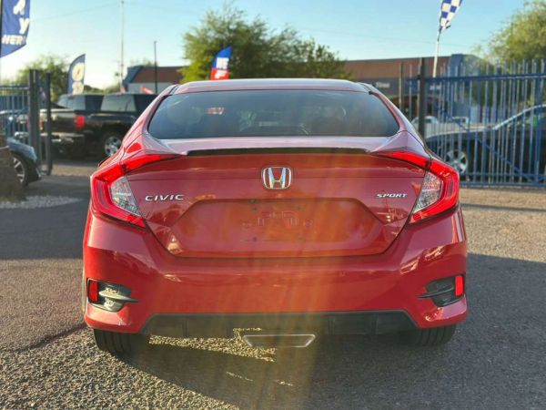 Rear view of a red Honda Civic Sport under sunlight.