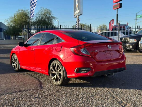Red Honda Civic hatchback parked outdoors.